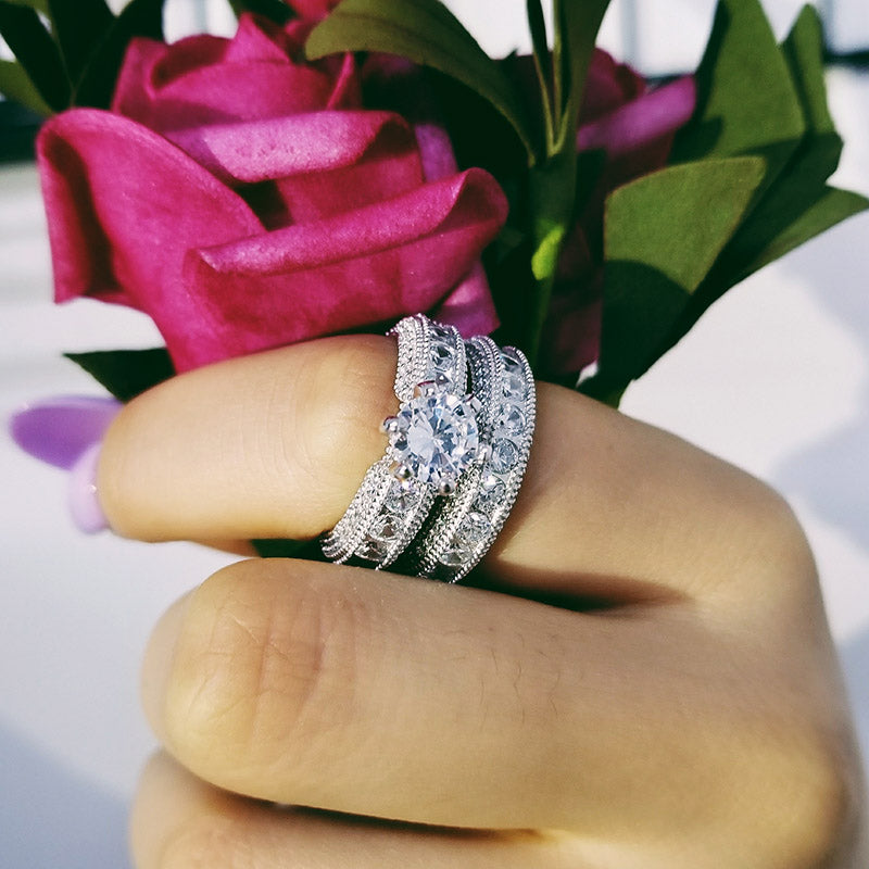 Zircon ring set with diamonds showcased on a hand holding pink roses, featuring 925 sterling silver craftsmanship.