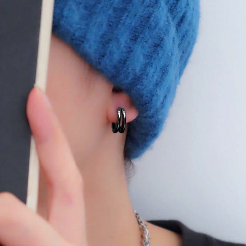 Close-up of a stylish person wearing a 316L stainless steel nose ring and cartilage earring.