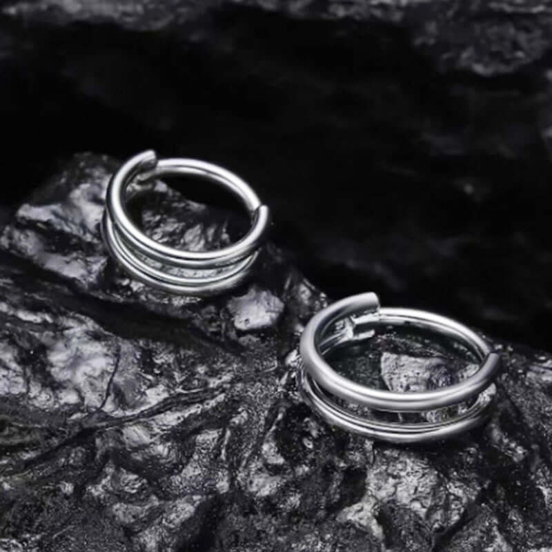 316L stainless steel nose ring and cartilage earring displayed on a textured black surface.
