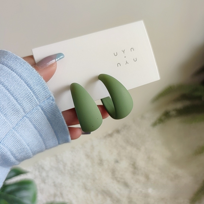 candy color earrings for women in green displayed in hand with packaging