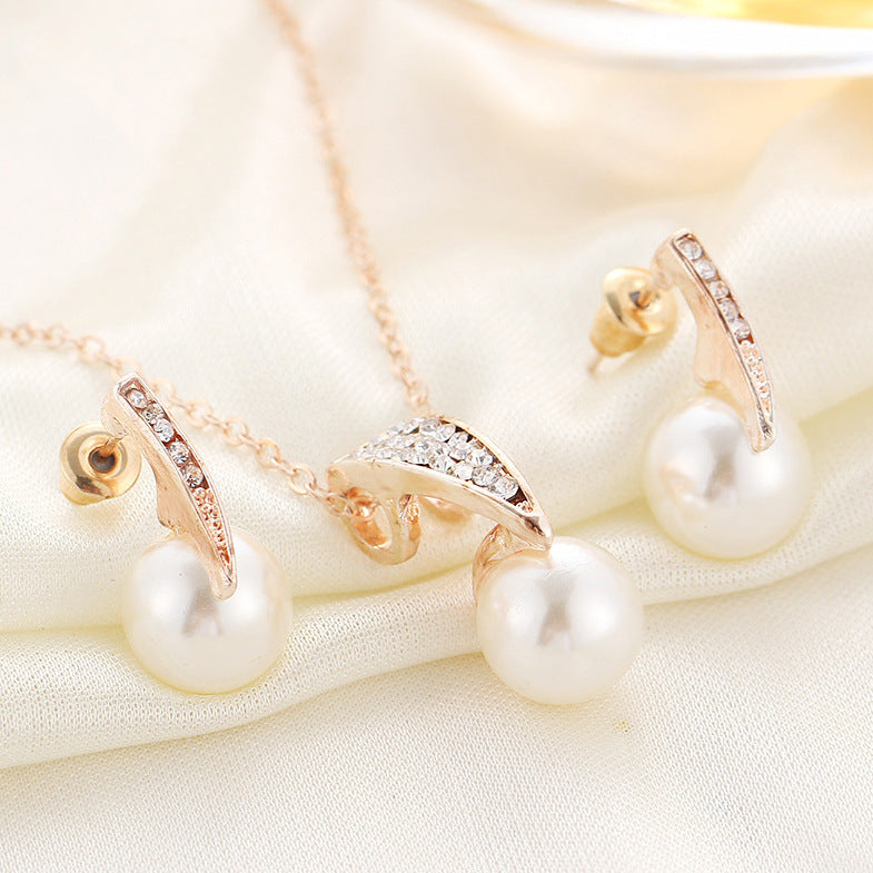bridal pearl necklace and earrings set featuring diamond-encrusted crystals and freshwater pearls on satin fabric.