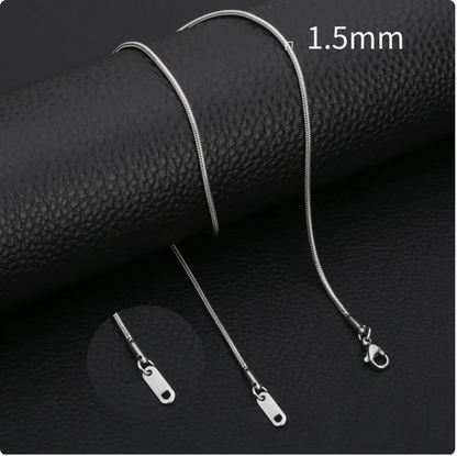 Minimalist stainless steel snake chain necklace on a black leather surface, featuring a 1.5mm width and smooth finish.